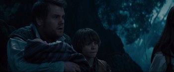 Movie still from “Into the Woods” (2014), directed by Rob Marshall – A man and a boy are standing next to each other in the dark; Medium shot, Over the shoulder angle