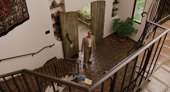 Movie still from “Intolerable Cruelty” (2003), directed by Joel Coen – A man walking down a tiled staircase in a house; Wide shot, Low angle