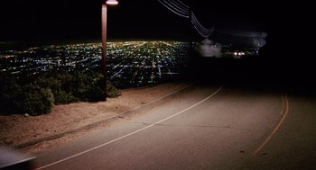 Movie still from “Intolerable Cruelty” (2003), directed by Joel Coen – A view of a city at night from the side of the road; Extreme Wide shot, High angle