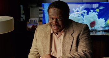 Movie still from “Intolerable Cruelty” (2003), directed by Joel Coen – A man wearing a brown jacket and a brown shirt; Close Up shot, High angle