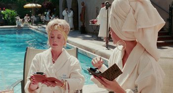 Movie still from “Intolerable Cruelty” (2003), directed by Joel Coen – Two women in white bathrobes are by a pool; Medium shot, Over the shoulder angle
