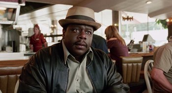 Movie still from “Intolerable Cruelty” (2003), directed by Joel Coen – A man in a hat and a leather jacket in a restaurant; Close Up shot, Low angle