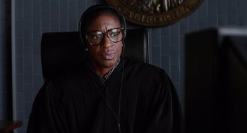 Movie still from “Intolerable Cruelty” (2003), directed by Joel Coen – A woman in a judge's robe listening to music; Close Up shot, Over the shoulder angle