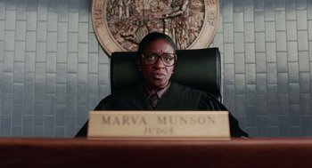 Movie still from “Intolerable Cruelty” (2003), directed by Joel Coen – A judge sitting at a judge's chair in front of a wall; Close Up shot, Low angle