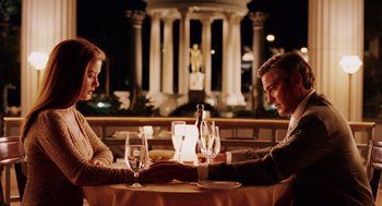 Movie still from “Intolerable Cruelty” (2003), directed by Joel Coen – A man and a woman sitting at a dinner table; Medium shot, Low angle