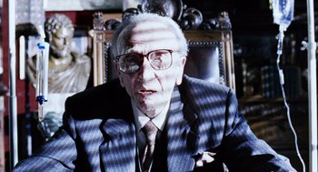 Movie still from “Intolerable Cruelty” (2003), directed by Joel Coen – An older man wearing a suit and tie; Close Up shot, Over the shoulder angle