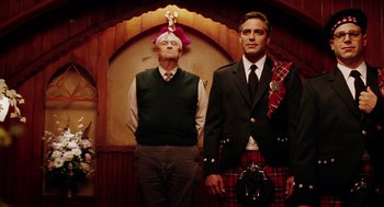 Movie still from “Intolerable Cruelty” (2003), directed by Joel Coen – A man in a kilt stands next to another man in a kilt; Medium shot, Low angle