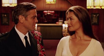 Movie still from “Intolerable Cruelty” (2003), directed by Joel Coen – A man and a woman standing next to each other; Close Up shot, Over the shoulder angle