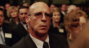 Movie still from “Intolerable Cruelty” (2003), directed by Joel Coen – An older man in a suit and tie with glasses; Close Up shot, Low angle