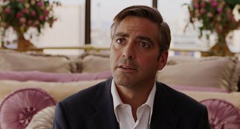 Movie still from “Intolerable Cruelty” (2003), directed by Joel Coen – A person wearing a suit and tie; Close Up shot, Over the shoulder angle