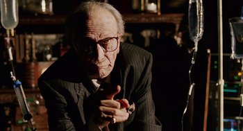 Movie still from “Intolerable Cruelty” (2003), directed by Joel Coen – An old man wearing glasses and a suit; Close Up shot, Over the shoulder angle