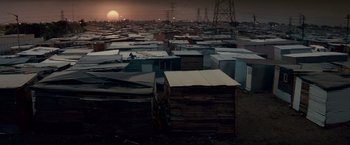 Movie still from “Invictus” (2009), directed by Clint Eastwood – The sun is setting over a city with many buildings; Extreme Wide shot, Low angle