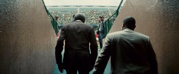 Movie still from “Invictus” (2009), directed by Clint Eastwood – A group of men in suits walking down a ramp; Medium shot, Low angle