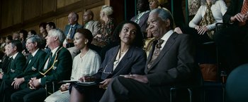 Movie still from “Invictus” (2009), directed by Clint Eastwood – A group of people sitting next to each other in a room; Medium shot, Low angle
