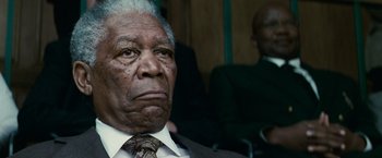 Movie still from “Invictus” (2009), directed by Clint Eastwood – An older man wearing a suit and tie; Close Up shot, Low angle
