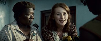 Movie still from “Invictus” (2009), directed by Clint Eastwood – A woman standing next to a man in a room; Close Up shot, Over the shoulder angle