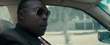 Movie still from “Invictus” (2009), directed by Clint Eastwood – A person in a car wearing sunglasses; Close Up shot, Low angle