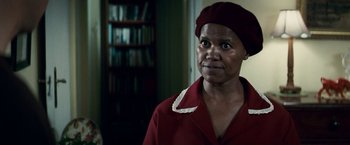 Movie still from “Invictus” (2009), directed by Clint Eastwood – An older woman wearing a red shirt and a red hat; Close Up shot, Over the shoulder angle