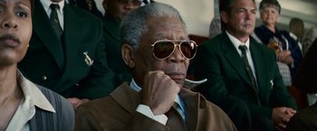 Movie still from “Invictus” (2009), directed by Clint Eastwood – An older man wearing a suit and sunglasses; Close Up shot, Low angle