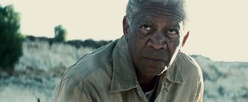 Movie still from “Invictus” (2009), directed by Clint Eastwood – An older man with a gray beard and a brown shirt; Close Up shot, Low angle