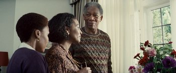 Movie still from “Invictus” (2009), directed by Clint Eastwood – An older man standing next to an older woman; Medium shot, Over the shoulder angle