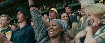 Movie still from “Invictus” (2009), directed by Clint Eastwood – A group of people in the stands at a sporting event; Medium shot, Low angle