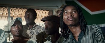 Movie still from “Invictus” (2009), directed by Clint Eastwood – A group of men standing next to each other in a room; Close Up shot, Low angle