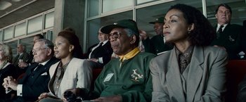 Movie still from “Invictus” (2009), directed by Clint Eastwood – An older man wearing a green jacket and a green hat; Medium shot, Low angle