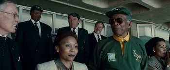 Movie still from “Invictus” (2009), directed by Clint Eastwood – A group of men and a woman standing next to each other; Medium shot, Low angle