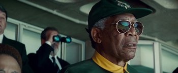 Movie still from “Invictus” (2009), directed by Clint Eastwood – A man wearing a green hat and sunglasses; Close Up shot, Low angle