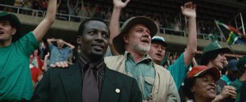 Movie still from “Invictus” (2009), directed by Clint Eastwood – A group of men standing next to each other in front of a crowd; Close Up shot, Low angle