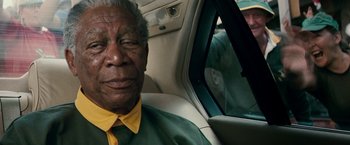 Movie still from “Invictus” (2009), directed by Clint Eastwood – An older man sitting in the back seat of a car; Close Up shot, Over the shoulder angle