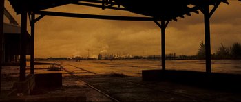 Movie still from “Invincible” (2006), directed by Ericson Core – An empty parking lot in front of an oil refinery; Extreme Wide shot, High angle