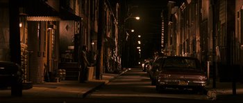Movie still from “Invincible” (2006), directed by Ericson Core – A man standing on the side of a street at night; Extreme Wide shot, High angle
