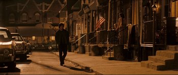 Movie still from “Invincible” (2006), directed by Ericson Core – A man walking down a street at night; Wide shot, Over the shoulder angle
