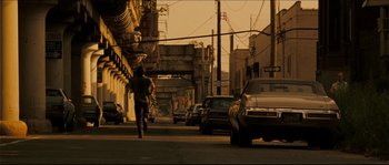 Movie still from “Invincible” (2006), directed by Ericson Core – A man running down the street in the middle of the day; Wide shot, Over the shoulder angle