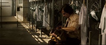 Movie still from “Invincible” (2006), directed by Ericson Core – A man sitting on a bench holding a purse; Medium shot, Low angle