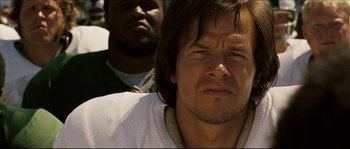 Movie still from “Invincible” (2006), directed by Ericson Core – A person with a person in the background; Close Up shot, Low angle