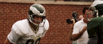 Movie still from “Invincible” (2006), directed by Ericson Core – A football player is taking a picture of another player; Close Up shot, Low angle