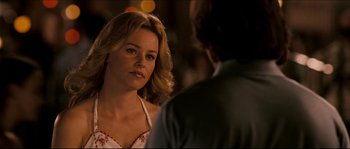 Movie still from “Invincible” (2006), directed by Ericson Core – A woman standing next to a man in a room; Close Up shot, Over the shoulder angle