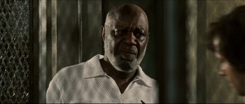 Movie still from “Invincible” (2006), directed by Ericson Core – An older man in a white shirt is looking at the camera; Close Up shot, Low angle