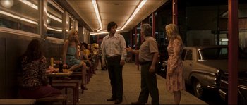 Movie still from “Invincible” (2006), directed by Ericson Core – A group of people standing on a sidewalk; Wide shot, Over the shoulder angle