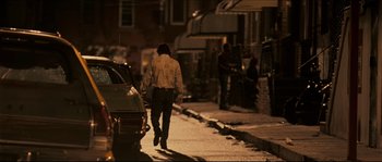 Movie still from “Invincible” (2006), directed by Ericson Core – A man walking down a street at night; Wide shot, Over the shoulder angle