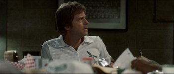 Movie still from “Invincible” (2006), directed by Ericson Core – A person sitting at a table; Close Up shot, Over the shoulder angle