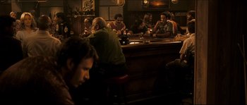 Movie still from “Invincible” (2006), directed by Ericson Core – A group of people sitting at a bar drinking beer; Wide shot, High angle