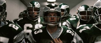 Movie still from “Invincible” (2006), directed by Ericson Core – A group of football players are lined up for a game; Close Up shot, Low angle
