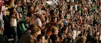 Movie still from “Invincible” (2006), directed by Ericson Core – A group of people sitting in the stands at a sporting event; Wide shot, High angle