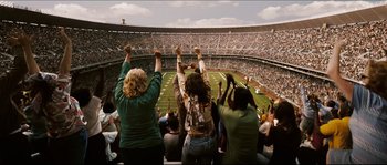 Movie still from “Invincible” (2006), directed by Ericson Core – A group of people standing on top of a football field; Extreme Wide shot, High angle