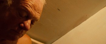 Movie still from “Irreversible” (2002), directed by Gaspar Noé – An old man with a beard is looking at a wall; Extreme Close Up shot, Low angle
