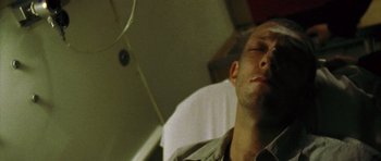 Movie still from “Irreversible” (2002), directed by Gaspar Noé – A person sleeping on a hospital bed; Close Up shot, High angle